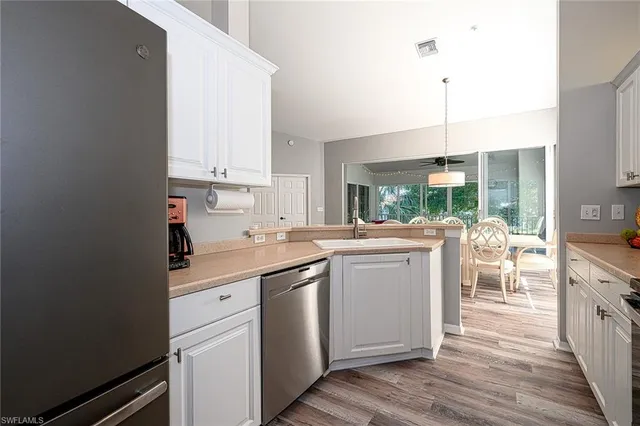 a kitchen with a sink window and cabinets