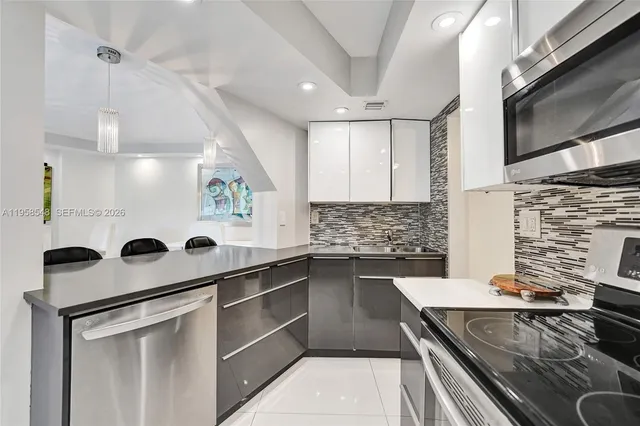 a kitchen with a sink appliances and cabinets