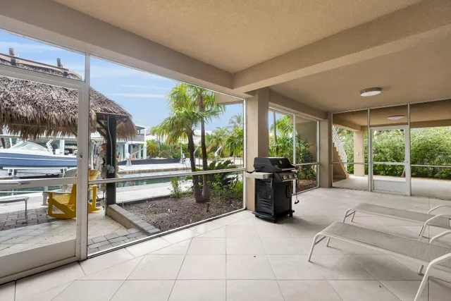 a living room with furniture a flat screen tv and floor to ceiling window