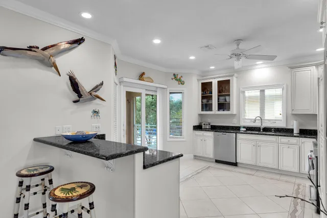 a kitchen with granite countertop a sink a stove and a refrigerator