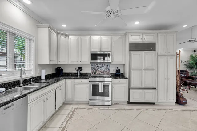a kitchen with stainless steel appliances granite countertop a stove a sink and a refrigerator
