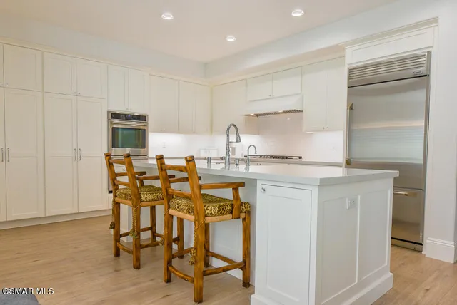 a kitchen with a table chairs refrigerator and microwave