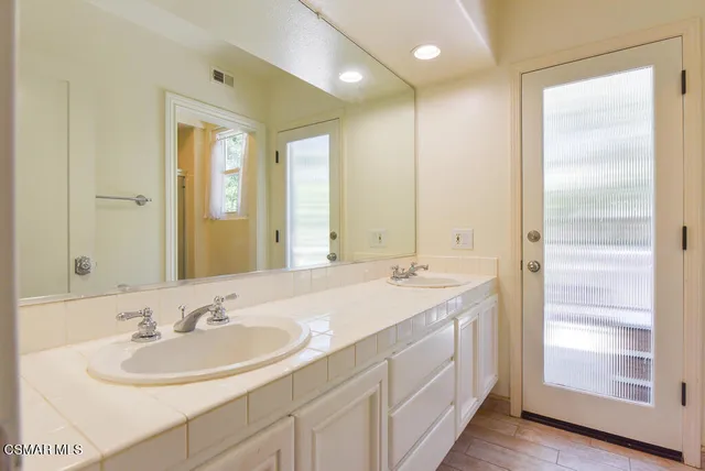a bathroom with a sink double vanity and a mirror