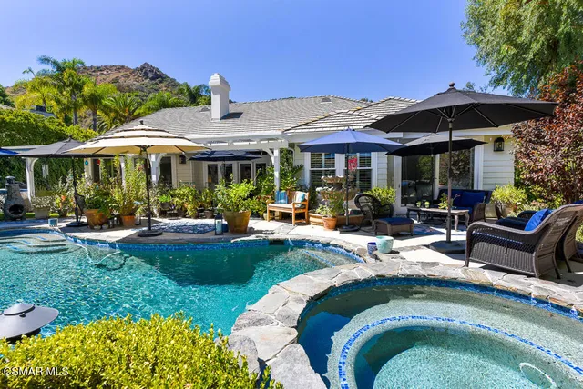 a view of a house with backyard swimming pool and sitting area