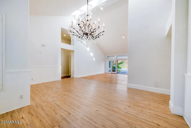 a view of a room with wooden floor and chandelier