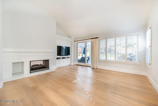 a view of empty room with a fireplace and windows