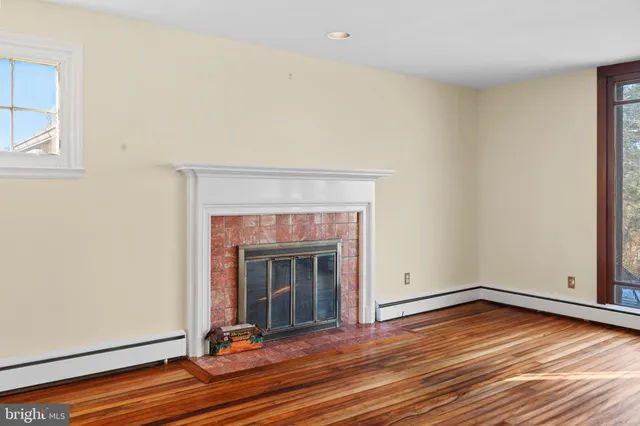 a view of a livingroom with wooden floor and a fireplace