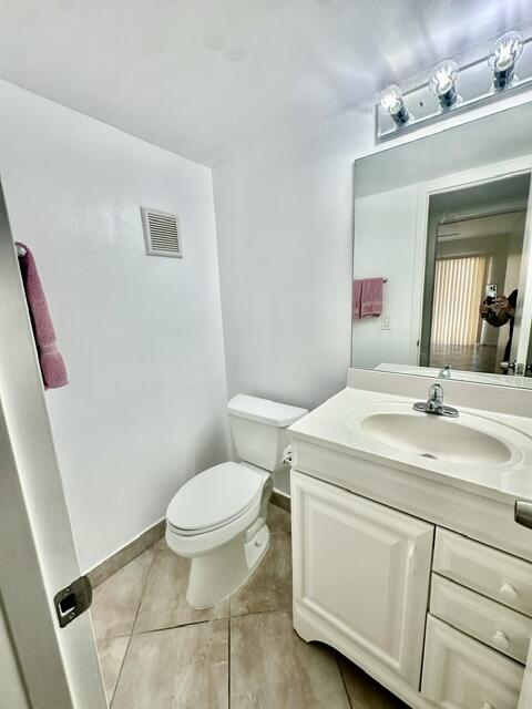 1047 Exeter C Boca Raton, FL 33434 - Photo 11 of 37 a bathroom with a granite countertop sink a toilet and a mirror