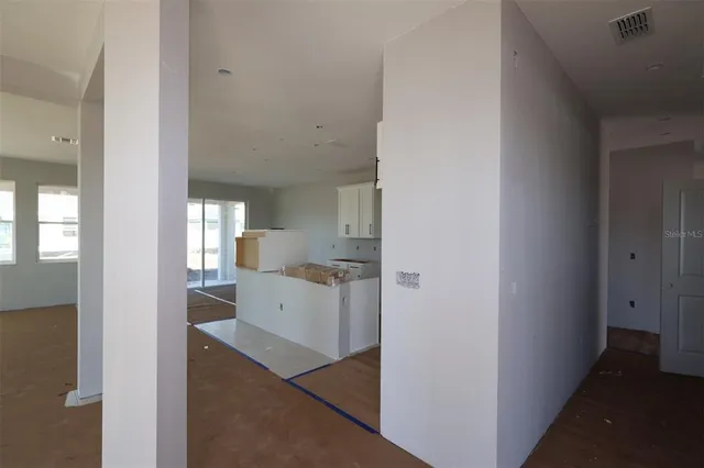 a kitchen with a refrigerator and white cabinets