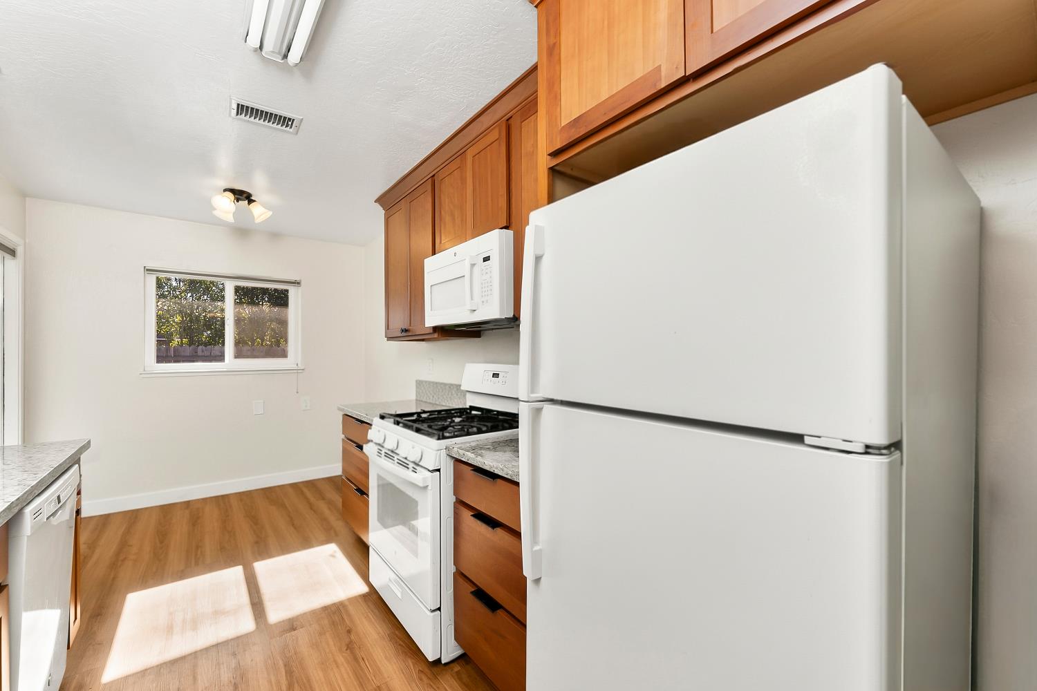 3620 Sean Drive Sacramento, CA 95821 - Photo 10 of 23 a kitchen with a refrigerator a stove and a wooden floor
