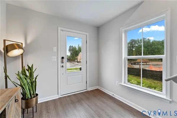 a view of empty room with wooden floor and window