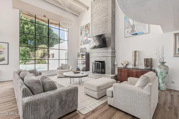 a living room with furniture fireplace and a large window