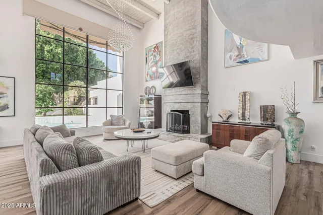 a living room with furniture fireplace and a large window