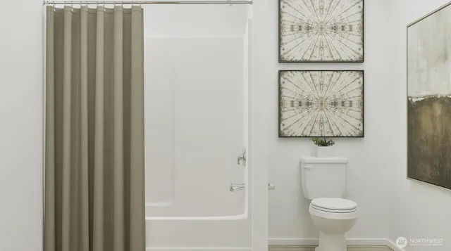 a white toilet sitting next to a shower curtain