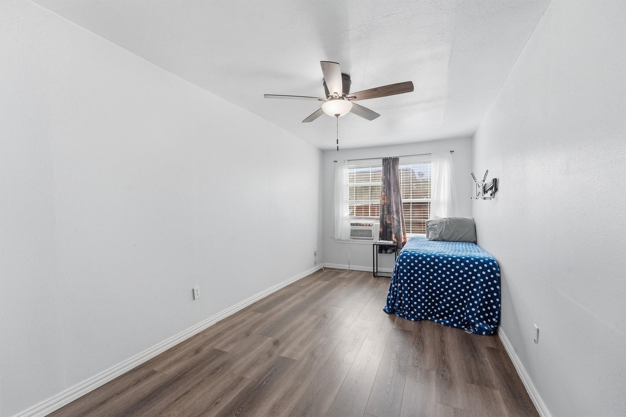 403 South Velasco Street Angleton, TX 77515 - Photo 11 of 25 a view of wooden floor and a chandelier fan in a room