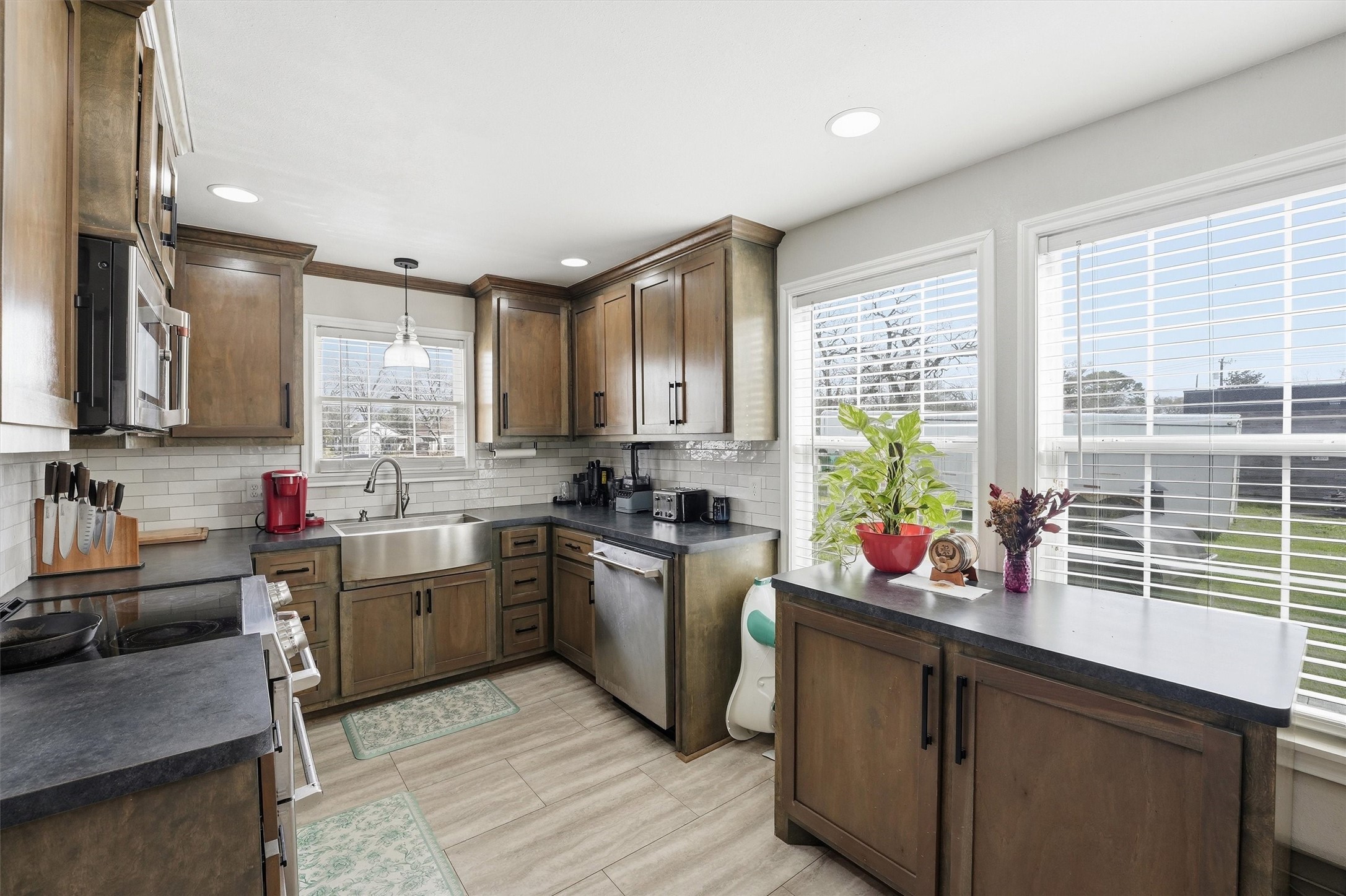 403 South Velasco Street Angleton, TX 77515 - Photo 13 of 25 a kitchen with stainless steel appliances granite countertop sink stove top oven and cabinets