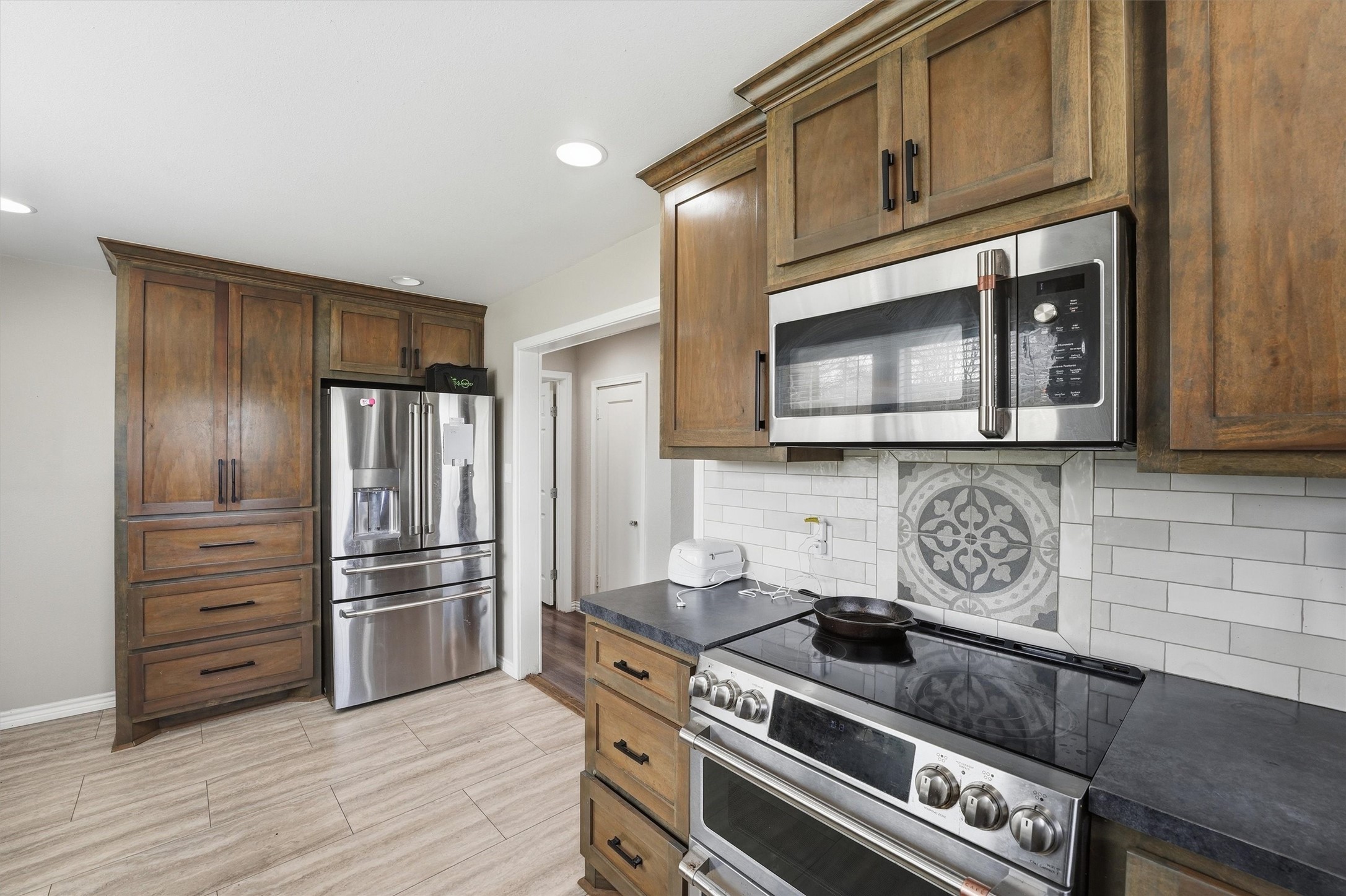403 South Velasco Street Angleton, TX 77515 - Photo 14 of 25 a kitchen with granite countertop cabinets and steel stainless steel appliances