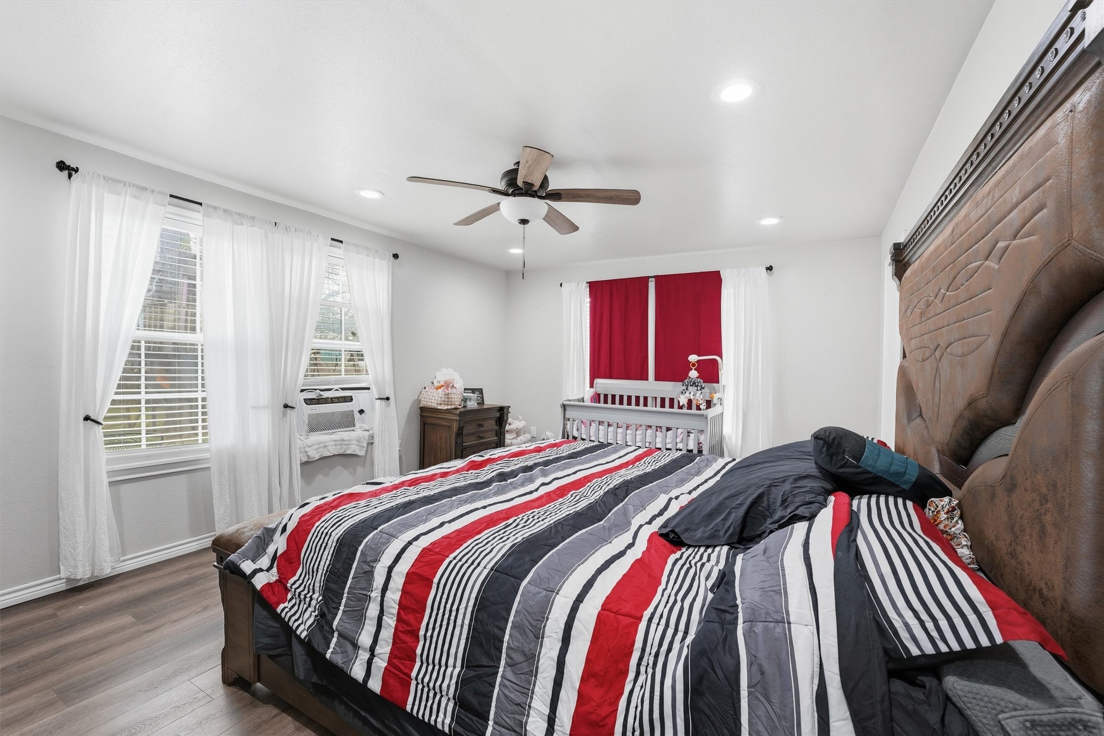 403 South Velasco Street Angleton, TX 77515 - Photo 8 of 25 a bedroom with a bed and a chandelier