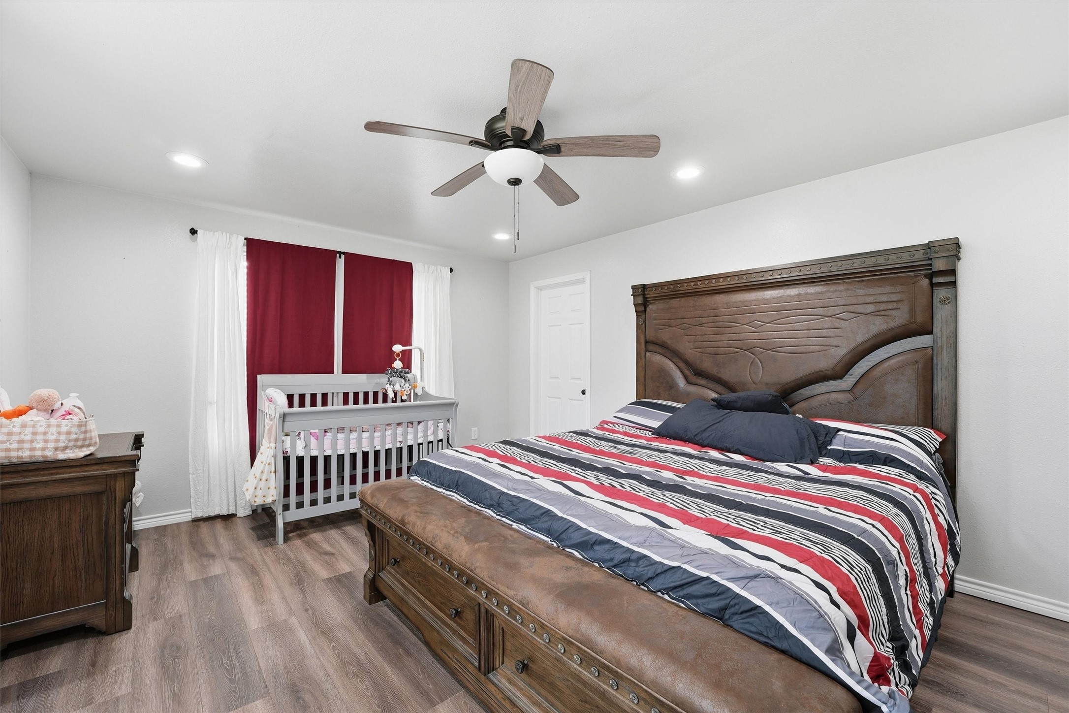 403 South Velasco Street Angleton, TX 77515 - Photo 9 of 25 a bedroom with a bed and a chandelier