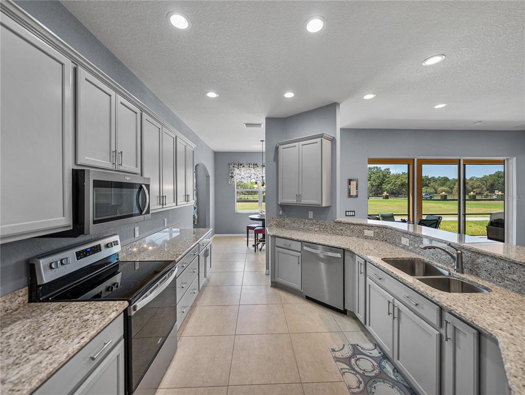 1124 Sawgrass Drive Winter Haven, FL 33859 - Photo 16 of 85 a large kitchen with stainless steel appliances granite countertop a sink and stove