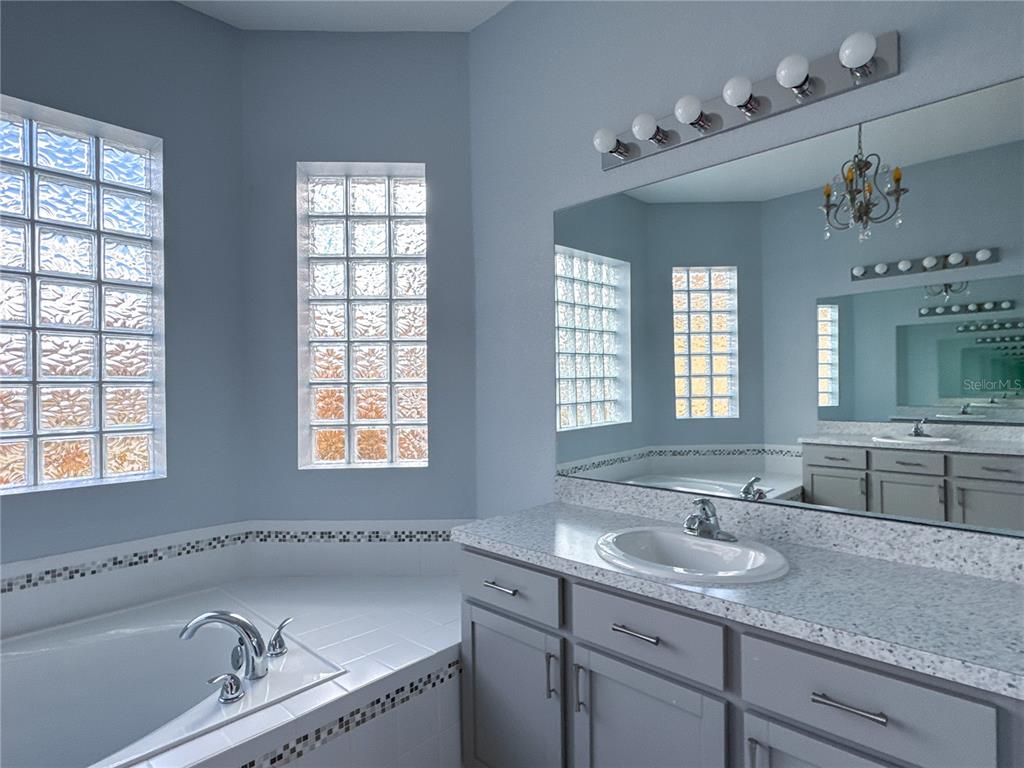 1124 Sawgrass Drive Winter Haven, FL 33859 - Photo 30 of 85 a bathroom with a granite countertop sink mirror double vanity and bathtub