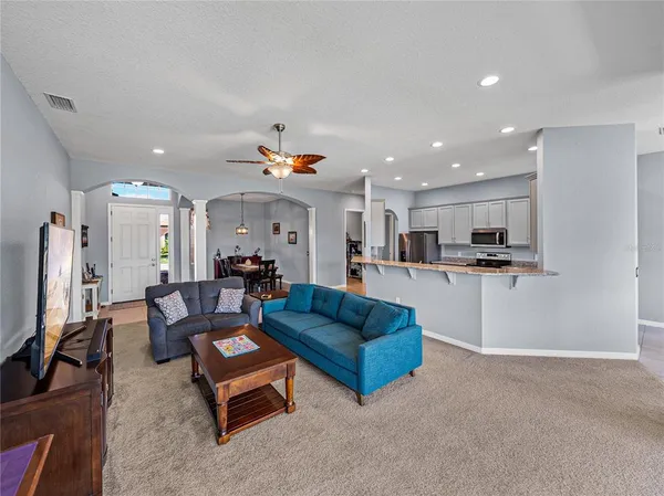 a large white kitchen with stainless steel appliances granite countertop a refrigerator and a stove top oven