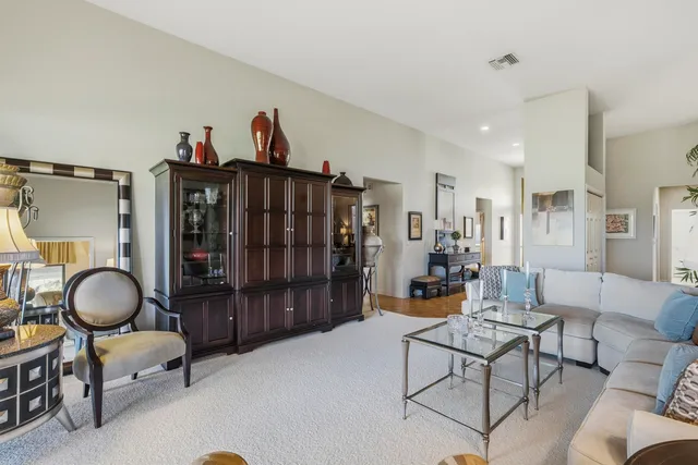 a open kitchen with stainless steel appliances granite countertop a stove top oven a sink dishwasher a dining table and chairs with wooden floor