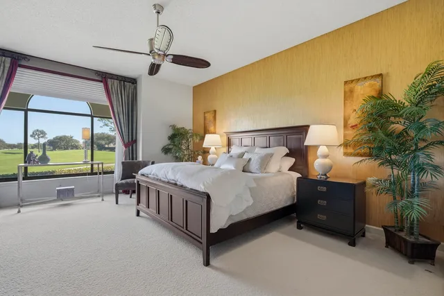 a bedroom with a bed couch chandelier and a window