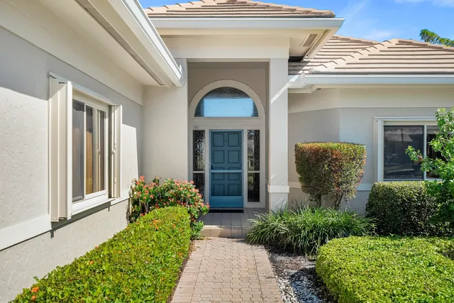 a front view of a house with potted plants