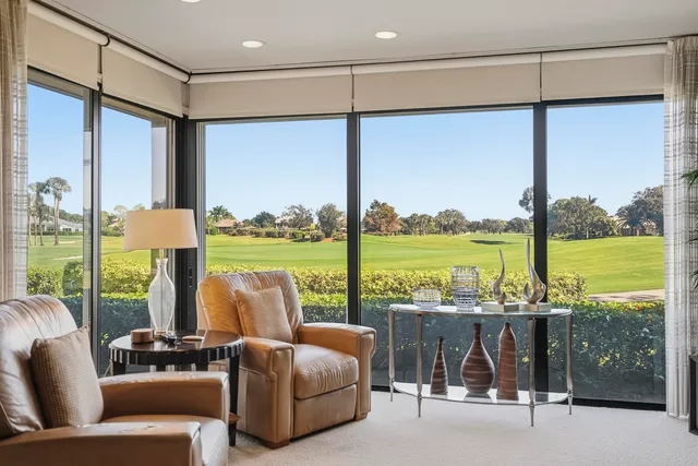 a living room with furniture flat screen tv and a floor to ceiling window