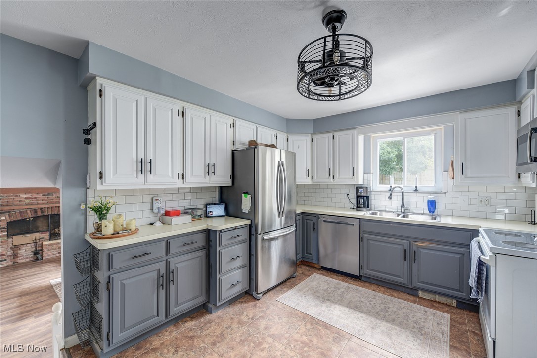 13765 Newton Road Cleveland, OH 44130 - Photo 13 of 42 Kitchen featuring gray cabinets, stainless steel appliances, white cabinetry, and decorative backsplash