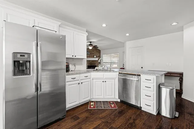a kitchen with white cabinets and stainless steel appliances