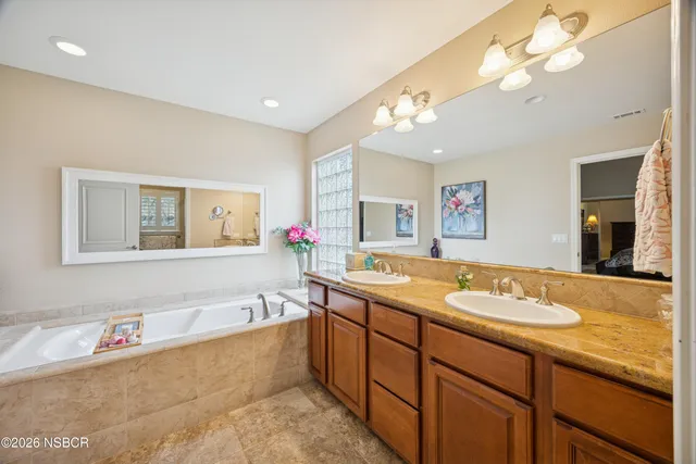 a bathroom with a tub sink and mirror
