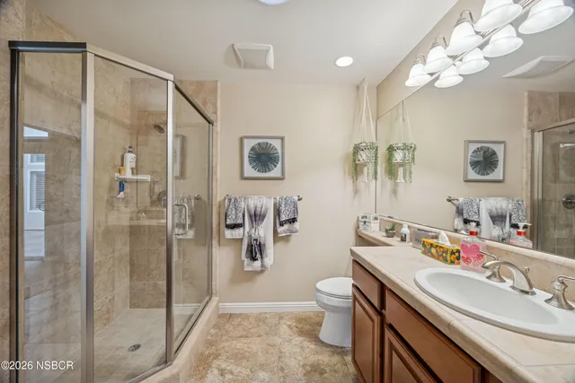 a bathroom with a double vanity sink mirror and toilet