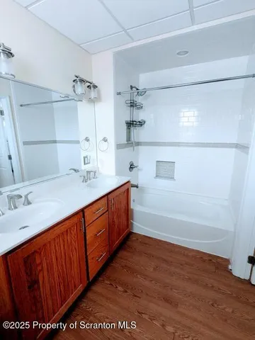 a bathroom with a tub sink and mirror