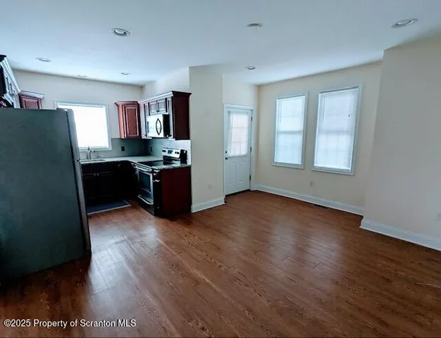 a living room with hard wood floors and furniture