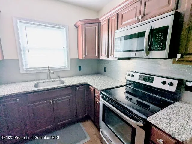 a kitchen with a stove a sink and a microwave