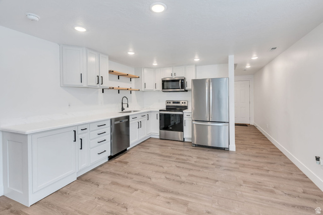 252 North Sunrise Rnch Drive Mapleton, UT 84664 - Photo 43 of 62 Contemporary kitchen featuring white cabinetry with black hardware, stainless steel appliances, wood-finish flooring, and recessed lighting