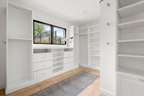 a view of walk in closet with empty racks