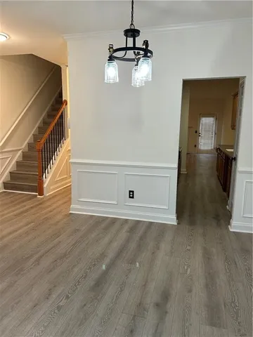 a view of a hallway with wooden floor and staircase