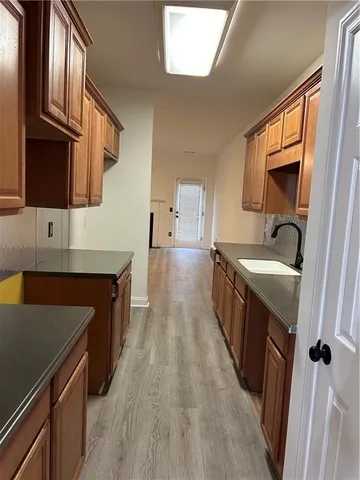a kitchen with granite countertop a sink stove and refrigerator