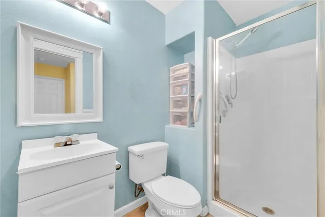 a bathroom with a toilet sink vanity and mirror