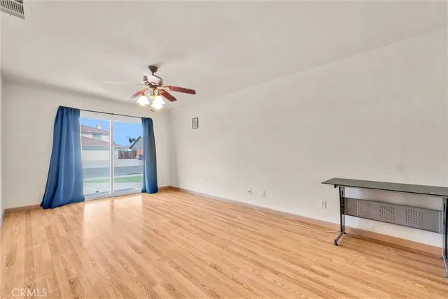a view of a livingroom with wooden floor and a ceiling fan