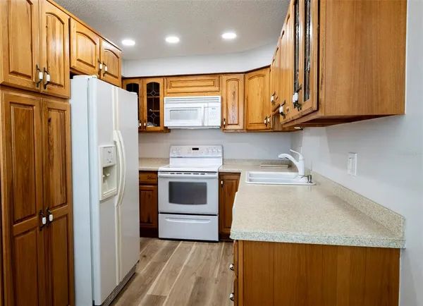 a kitchen with stainless steel appliances granite countertop a sink a stove and cabinets