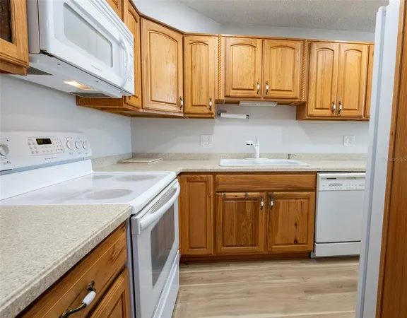 a kitchen with stainless steel appliances granite countertop a sink a stove and cabinets