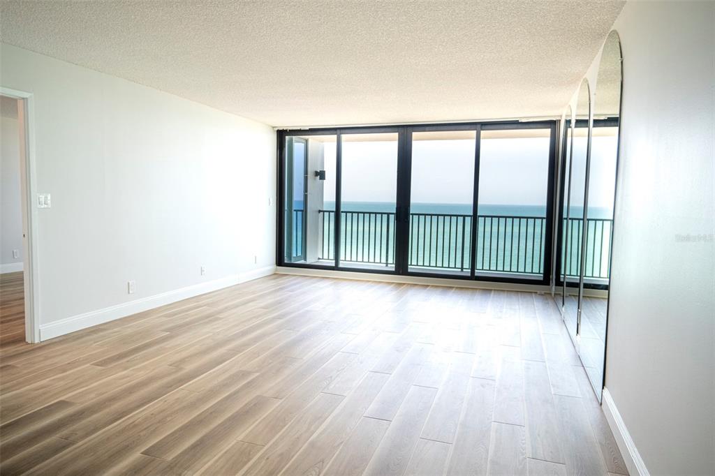 7100 Sunset Way, Unit 810 St. Pete Beach, FL 33706 - Photo 8 of 42 an empty room with wooden floor and windows