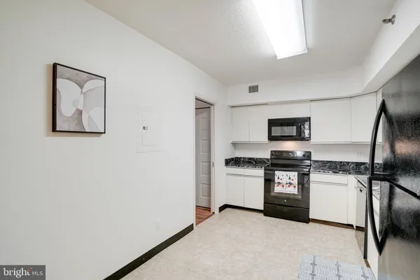 a kitchen with stainless steel appliances granite countertop a refrigerator sink and stove