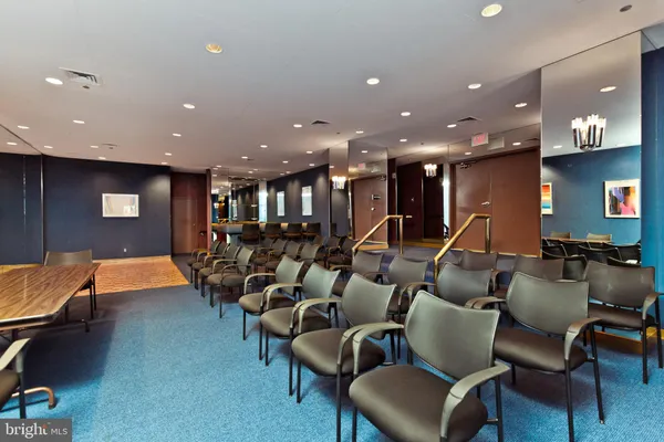 a group of people sitting in a room with kitchen view
