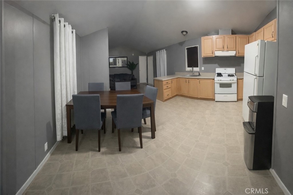 135 North Pepper Avenue, Unit 7 Rialto, CA 92376 - Photo 3 of 8 a living room with stainless steel appliances furniture a dining table and a refrigerator