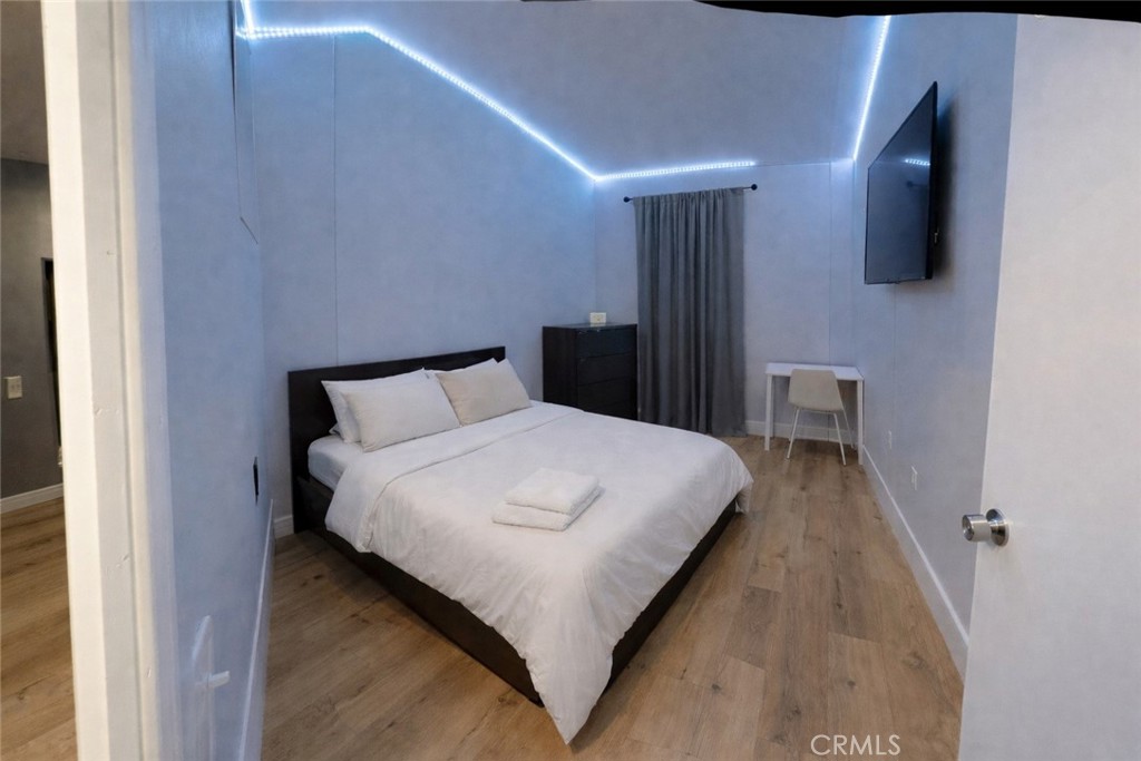 135 North Pepper Avenue, Unit 7 Rialto, CA 92376 - Photo 4 of 8 a bedroom with a bed and a flat tv screen on a dresser